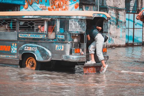 Free Jeepney navigating through a flooded street in Malabon, Metro Manila. Stock Photo