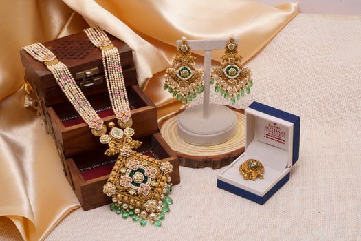 Exquisite Indian jewelry set featuring a necklace, earrings, and ring adorned with intricate designs and colorful gems.
