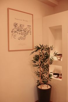 Warm minimalist interior with bamboo, artistic poster, and decorative bowls.