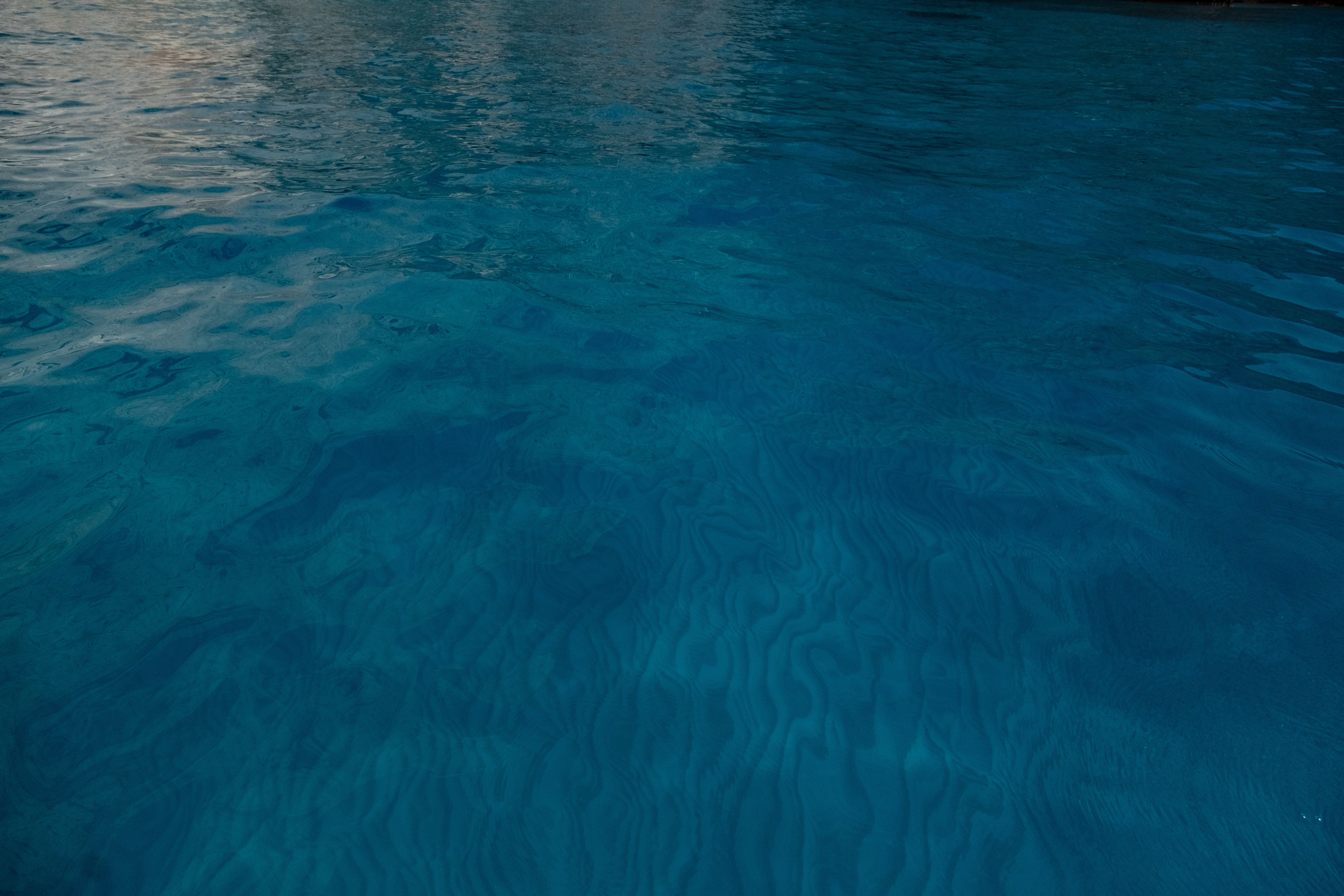 Peaceful view of a calm blue water surface with gentle ripples during the day.