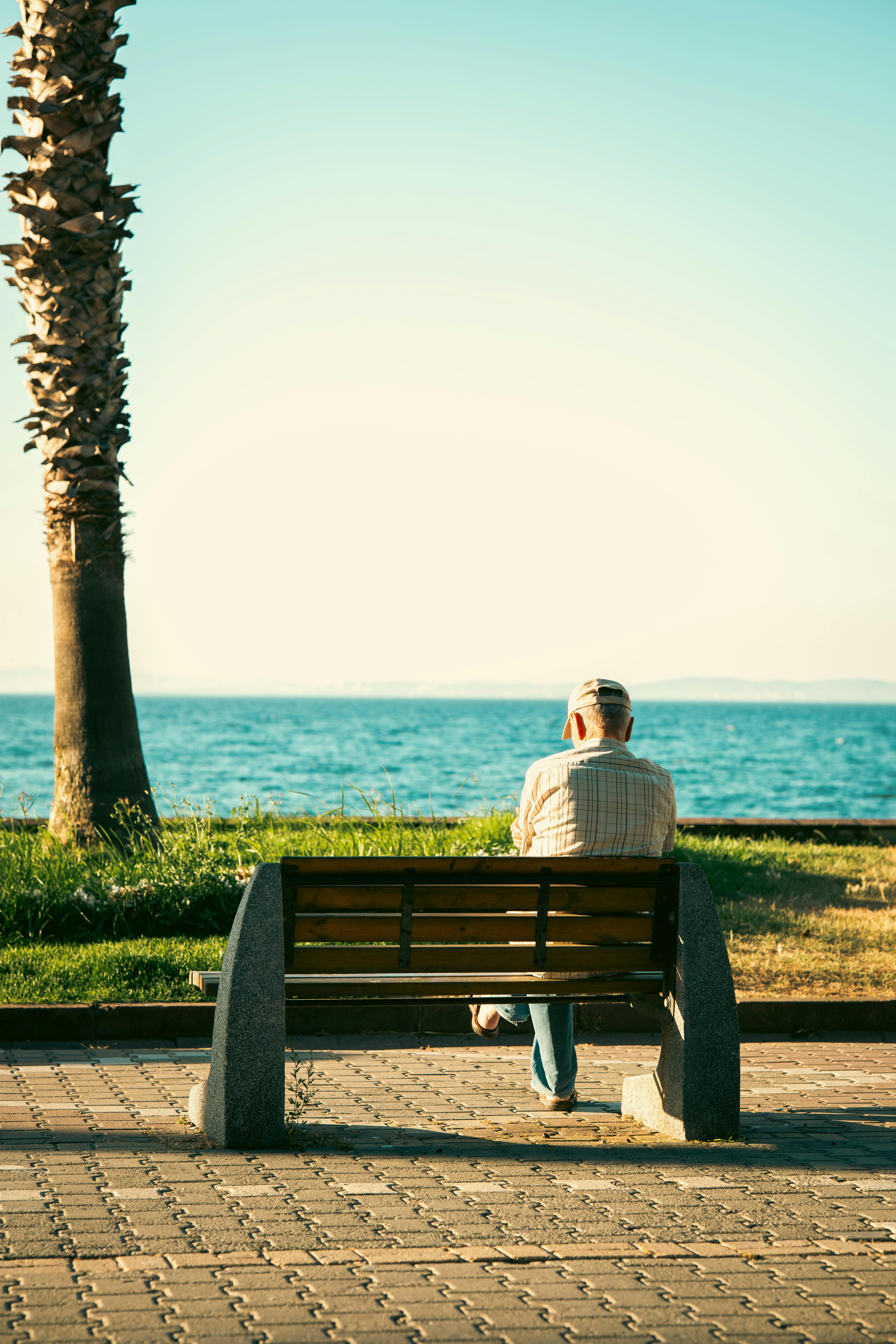 Elderly man enjoys the tranquil seaside view on a sunny day in Yalova, Türkiye.