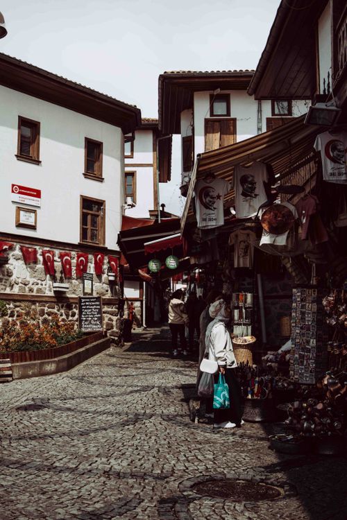 Free Explore a charming Turkish street market with cultural shops and cobblestone paths. Stock Photo