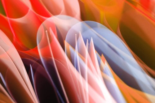 Free Vibrant abstract image featuring flowing light streaks in red, orange, and blue tones. Stock Photo