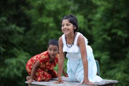 Free Two children in vibrant clothing enjoying playtime outside on a summer day. Stock Photo