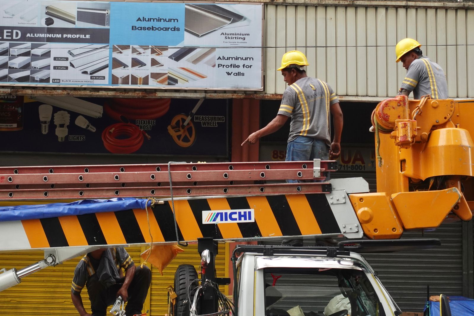 Construction professionals working on a building facade using a boom lift