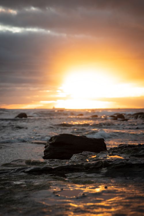 Free A stunning sunrise illuminates the rocky coastline of Sunshine Coast, Australia. Stock Photo