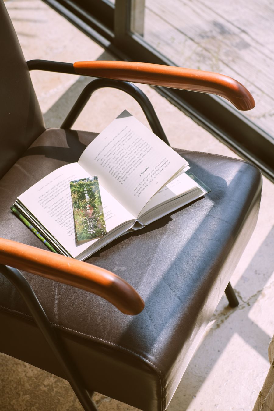 Open book resting on a leather chair in raking daylight &mdash; photo by 光术 山影 on Pexels