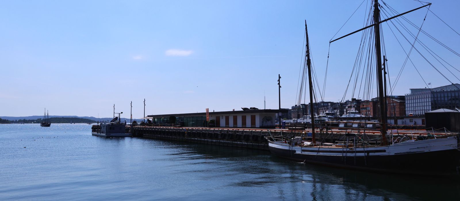 Sailboats anchored at Oslo marina on a clear summer day, showcasing serene waters and blue skies. — flights from Krakow to Oslo