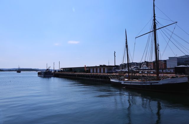 Sailboats anchored at Oslo marina on a clear summer day, showcasing serene waters and blue skies. — arriving in Sandefjord