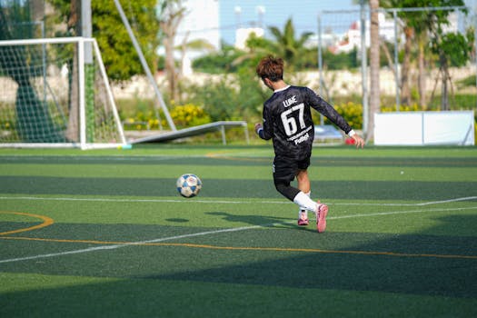 Captured moment of a young soccer player kicking the ball on a sunny outdoor field.