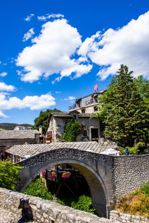 Free Charming stone bridge with Ottoman architecture and vibrant foliage in a sunny setting. Stock Photo