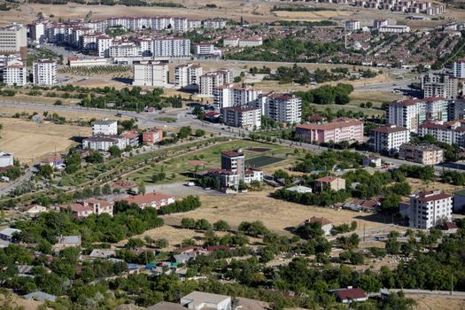 Aerial cityscape of Elâzığ, Türkiye showcasing apartments and greenery in summer.