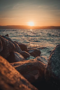 日落时海洋与岩石前景令人叹为观止，捕捉自然之美
