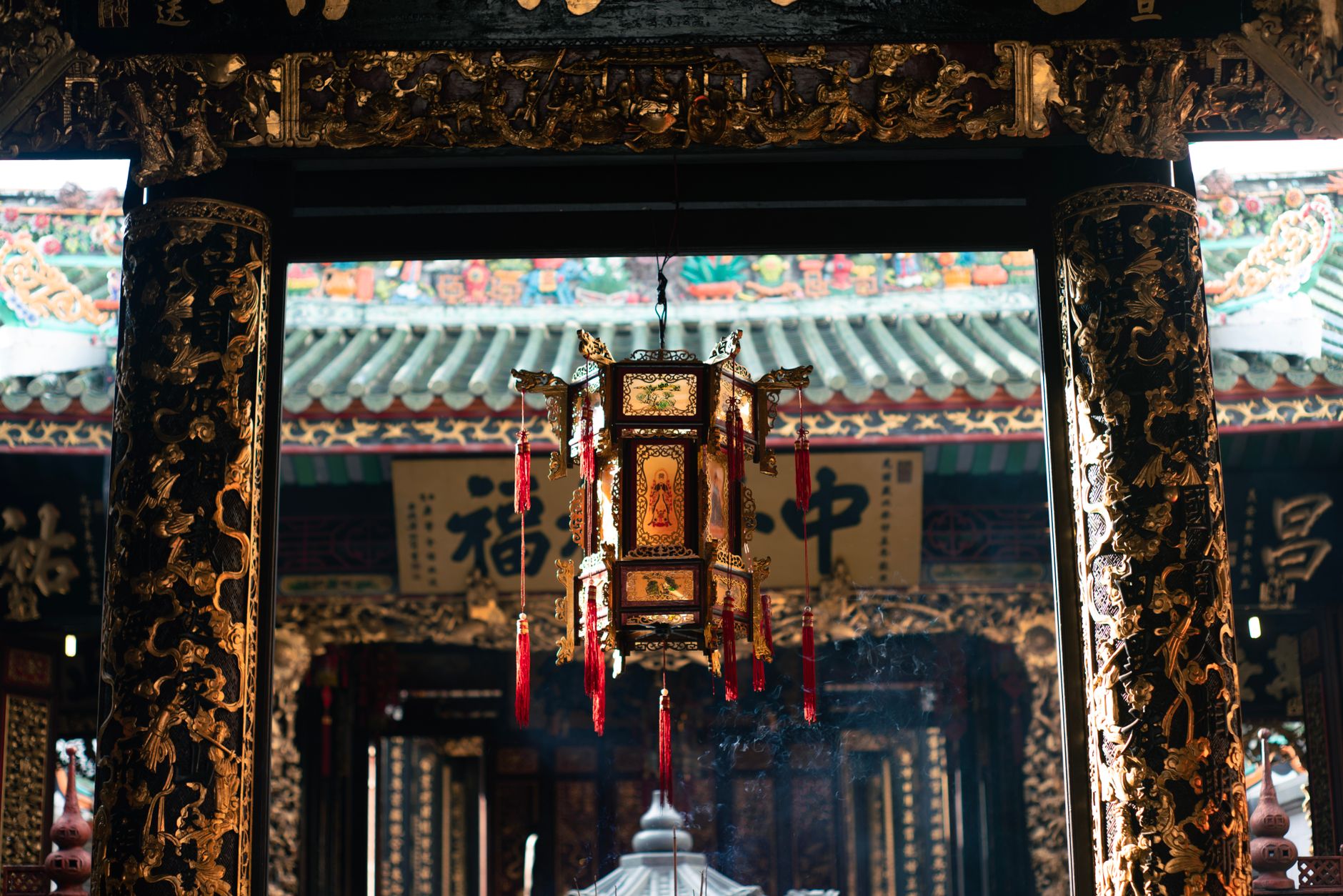 Exquisitely decorated temple lantern illuminated by sunlight, showcasing traditional Asian artistry.