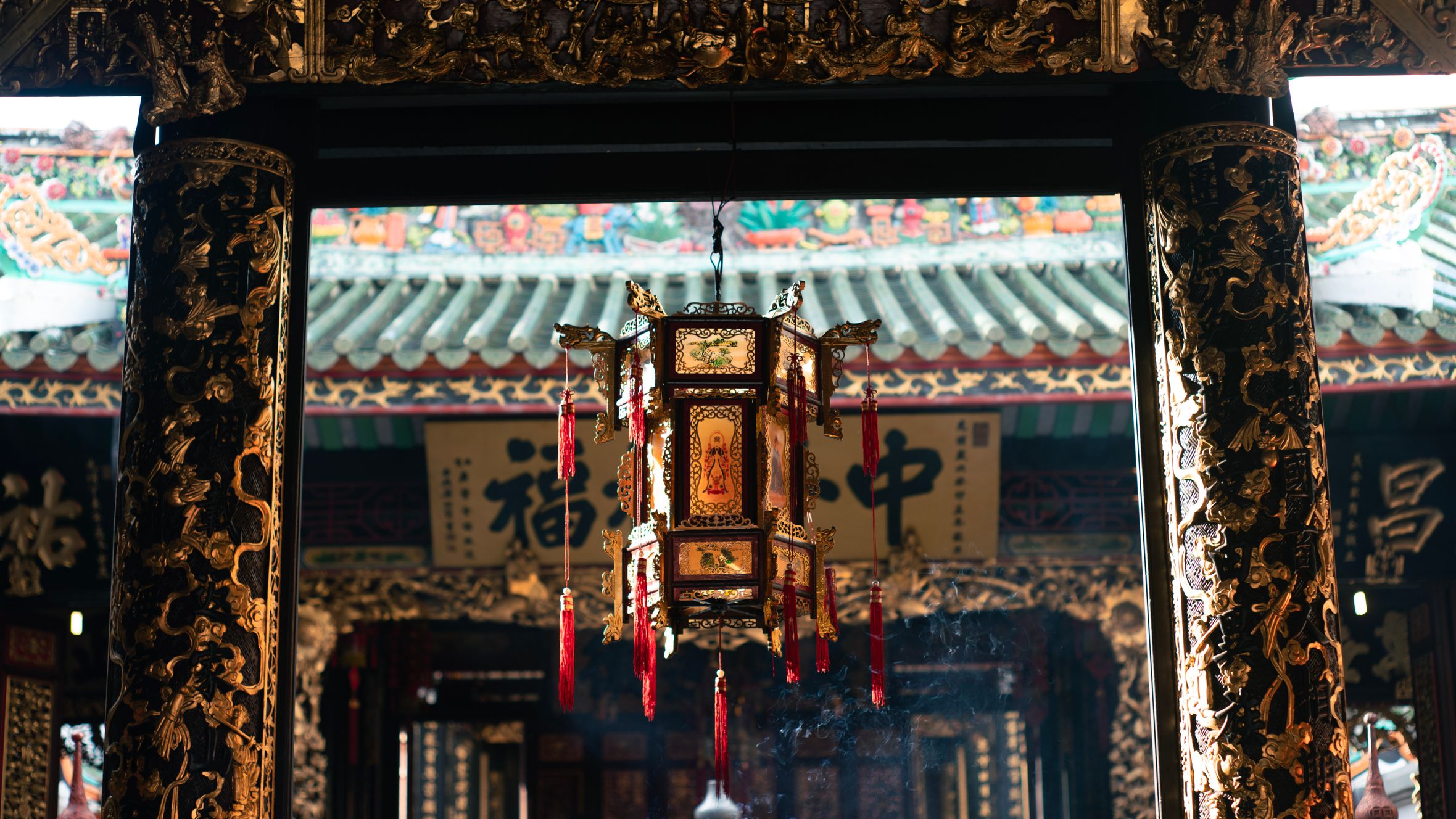 Exquisitely decorated temple lantern illuminated by sunlight, showcasing traditional Asian artistry.