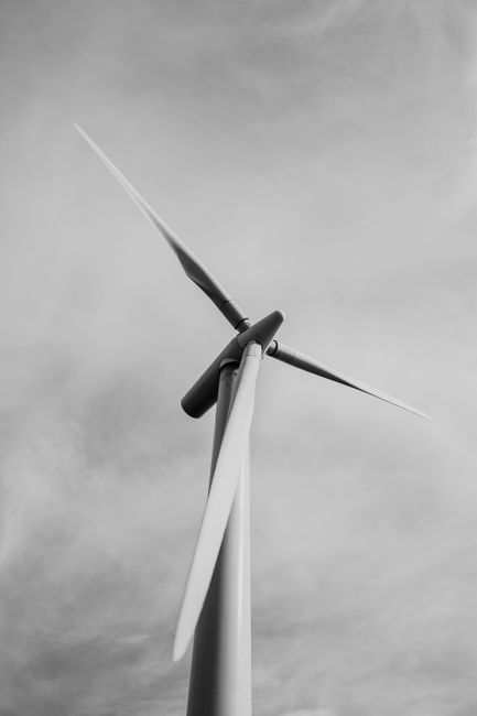 Close-up view of a wind turbine in black and white, symbolizing renewable energy.