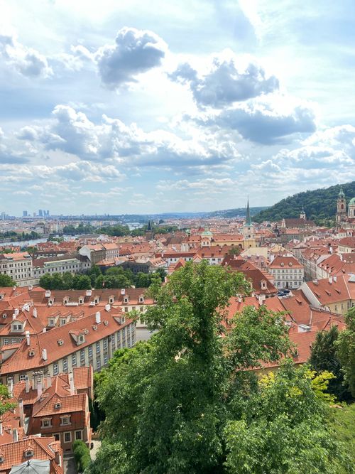 Free Scenic aerial view of Prague's red rooftops under a vibrant sky. Stock Photo