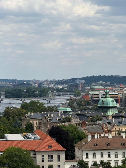 Free Breathtaking aerial view of historic Prague cityscape featuring Vltava River and iconic architecture under cloudy sky. Stock Photo