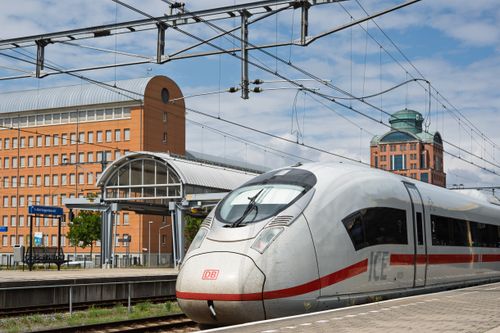 Free Modern high-speed train approaching a station in an urban setting on a clear day. Stock Photo