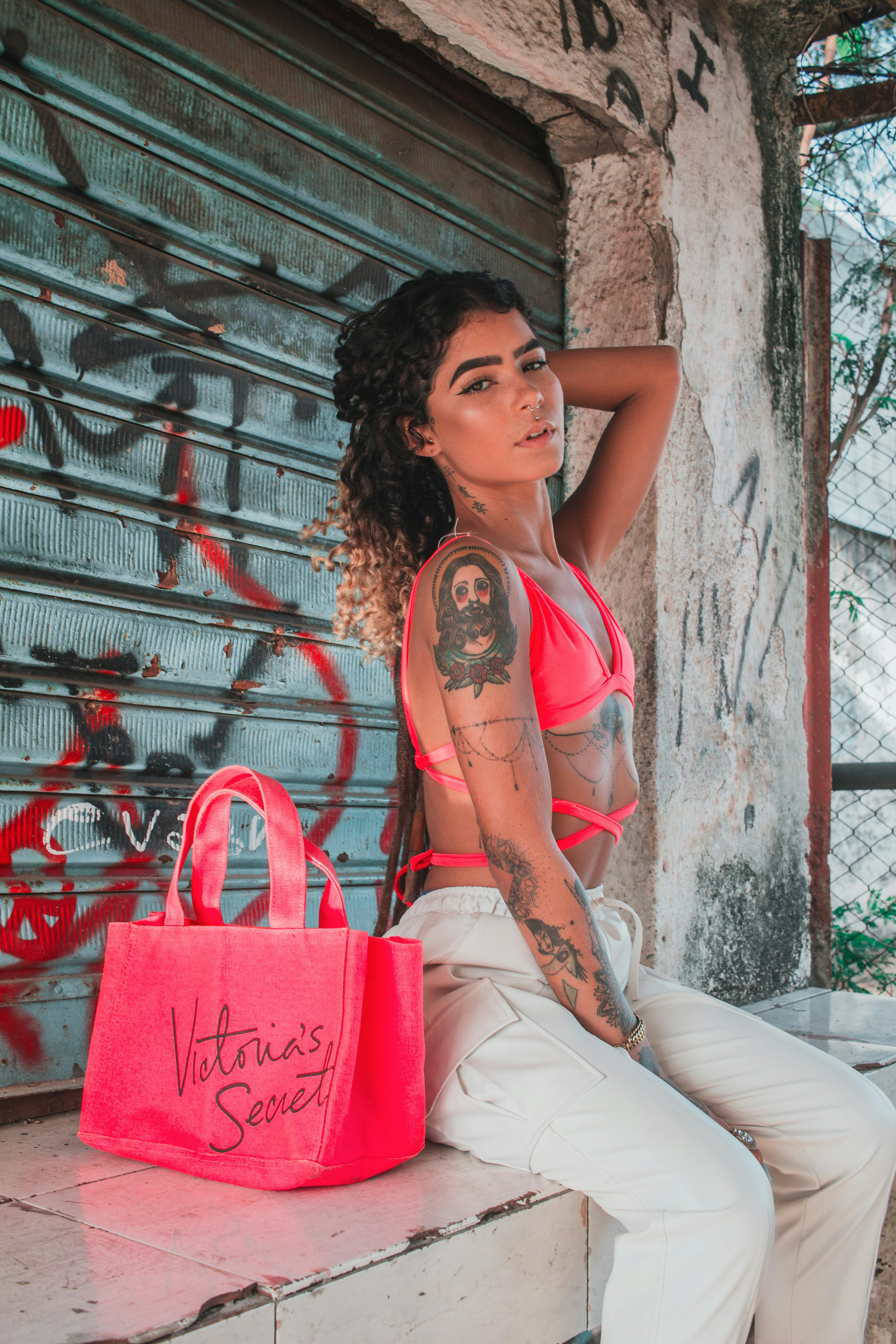 自信的女性手持时尚包在城市中摆出夏日风情的姿势