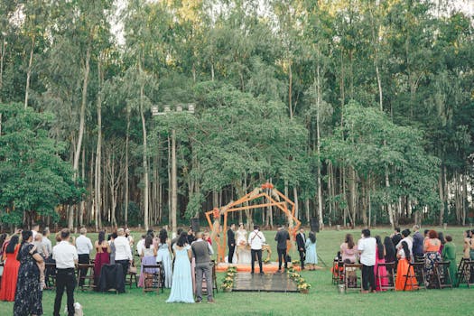 Beautiful outdoor wedding ceremony in a lush forest setting with a diverse group attending.