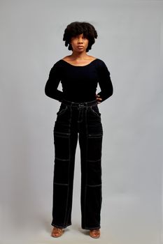 Young woman in fashionable outfit posing confidently indoors.