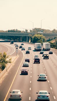 A vibrant highway showcasing traffic with cars and trucks under a clear sky.