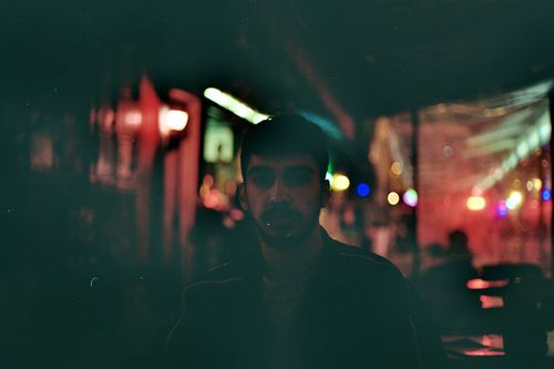 Free Atmospheric street portrait captured at night under soft, colorful lights in İzmir. Stock Photo