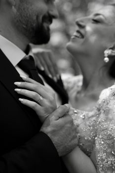 A close-up black and white photo of a joyful newlywed couple enjoying their special day.