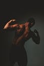 Silhouette of a Muscular Man Flexing in Low Light