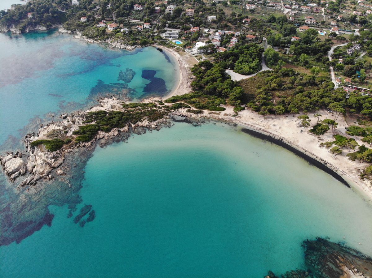 Coasta peninsulei Sithonia din Halkidiki, cu golfuri turcoaz și case răsfirate pe deal