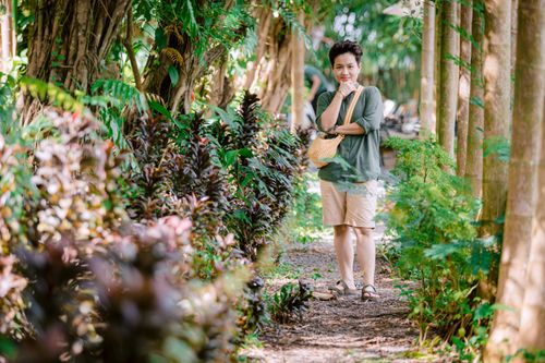 Free A woman strolling through a lush green garden path, embracing nature's tranquility. Stock Photo