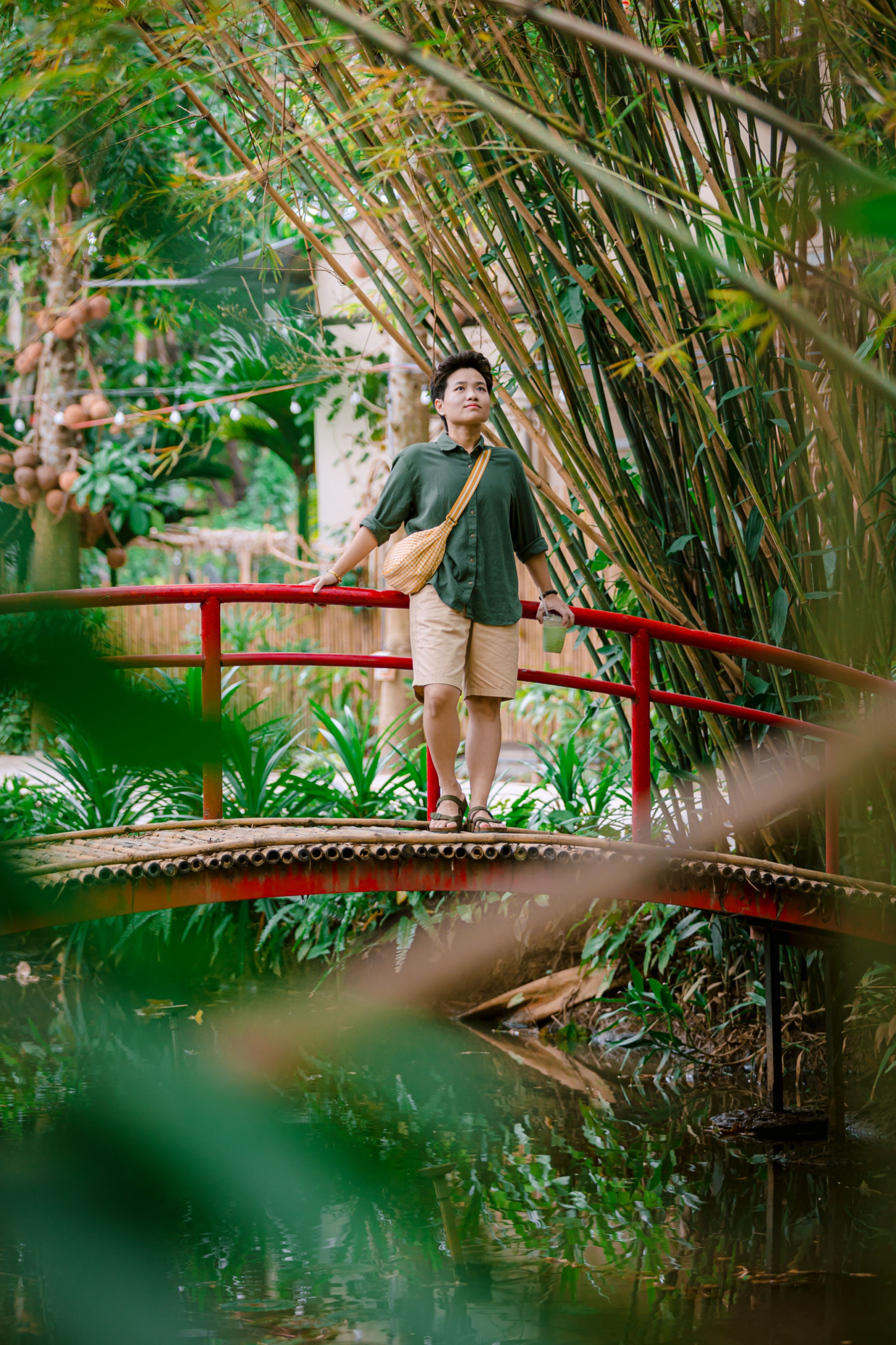 Man on Bamboo Bridge in Lush Green Garden