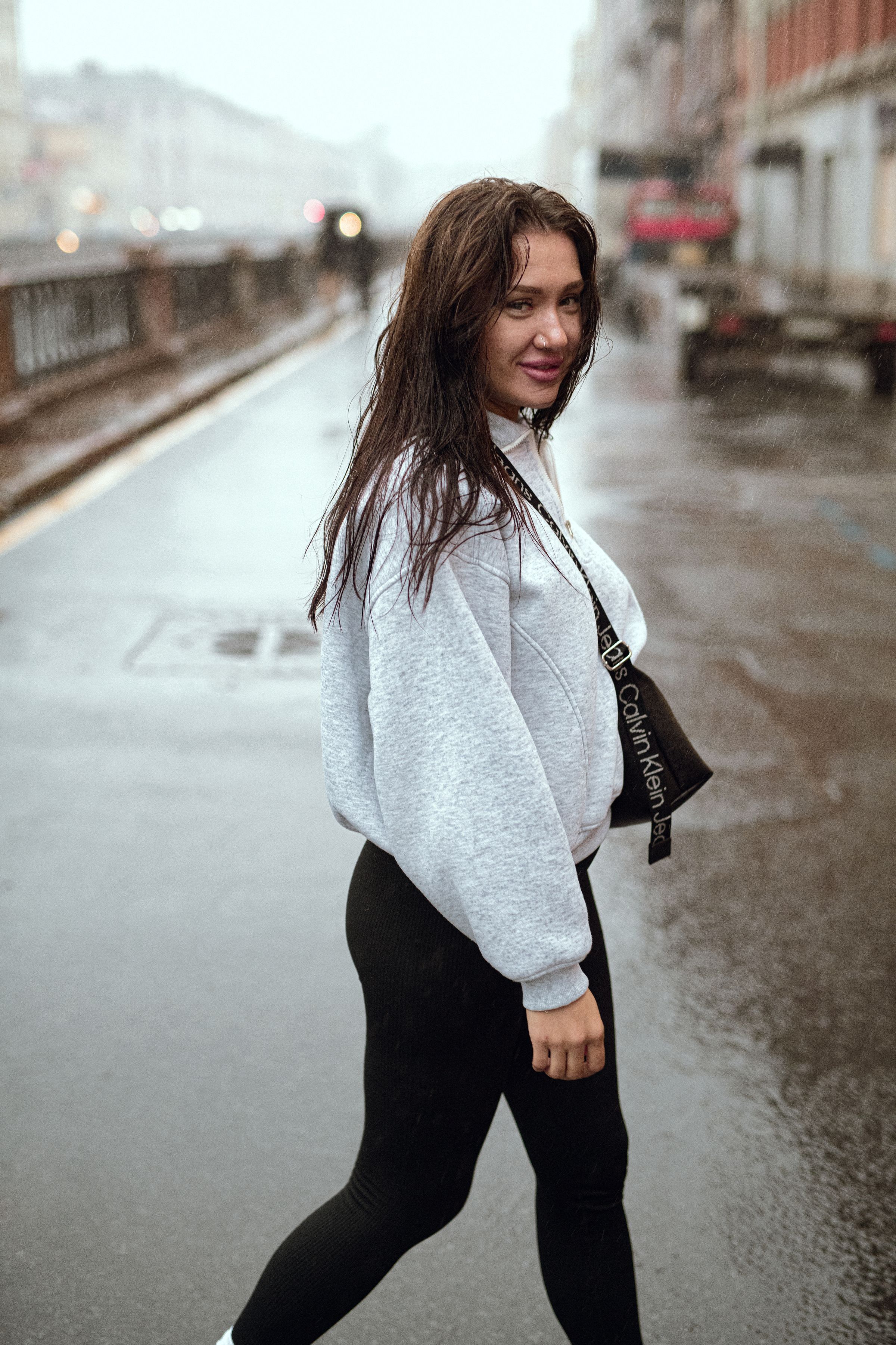 Person walking through a rainy city street in summer wearing a lightweight rain jacket and quick-dry shorts