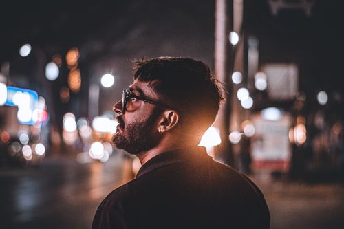 Free A captivating portrait of a man in Pune, India, with vibrant city lights at night. Stock Photo