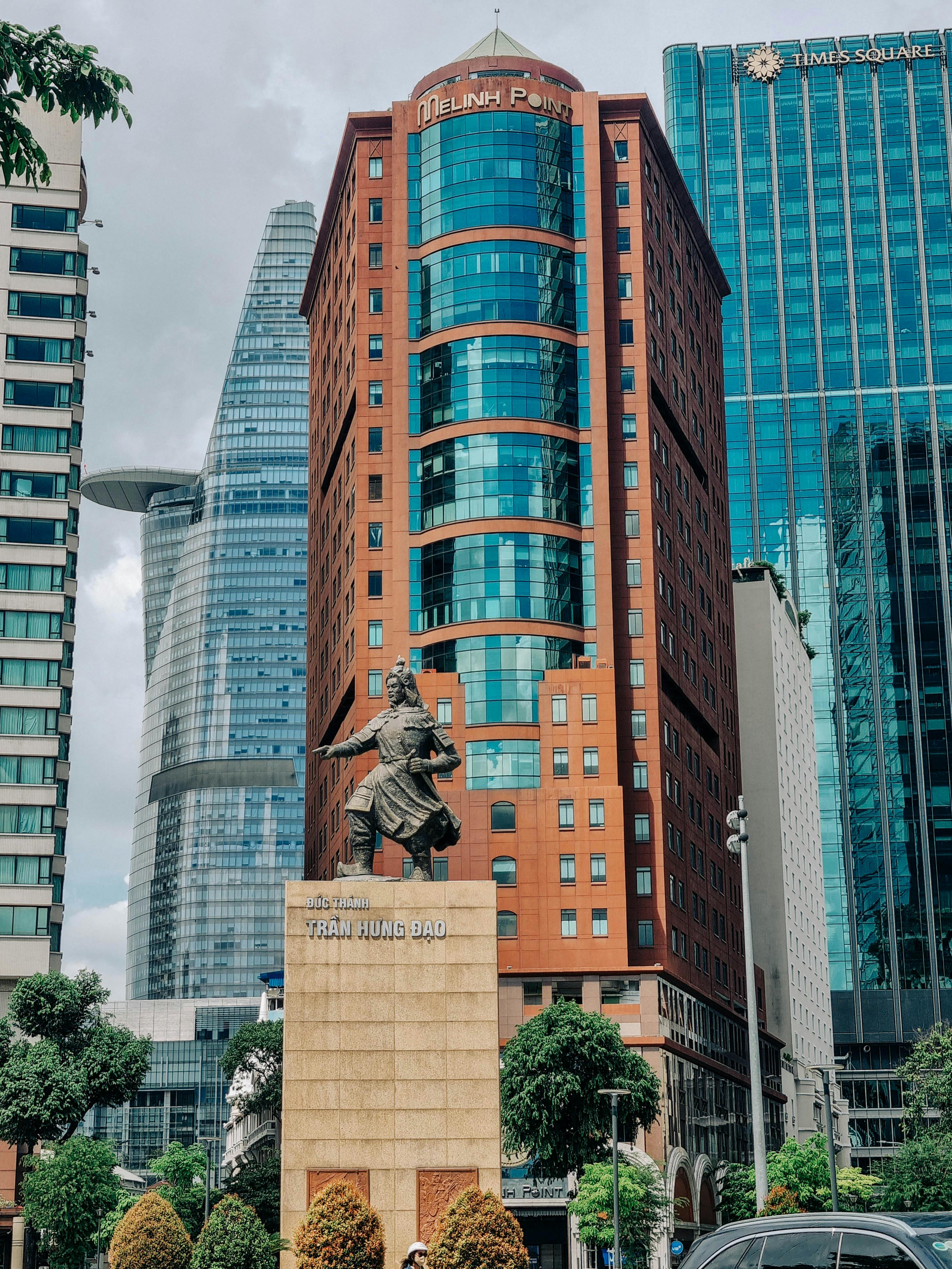 Statue of Tran Hung Dao amidst modern skyscrapers in Ho Chi Minh City, Vietnam.