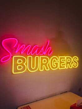 Bright neon sign reading 'Smash Burgers' in a cozy restaurant setting, perfect for dining ambiance.