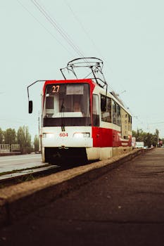 Vintage red tram riding along the city streets under an overcast sky, tram number 604.