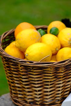 A wicker basket filled with ripe lemons and limes, captured outdoors on a bright day.