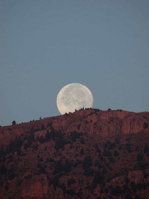 Free Stunning view of full moon rising over rugged mountain ridge at twilight. Stock Photo