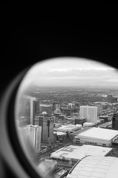 Free A dramatic black and white aerial cityscape seen through an airplane window, capturing urban architecture. Stock Photo