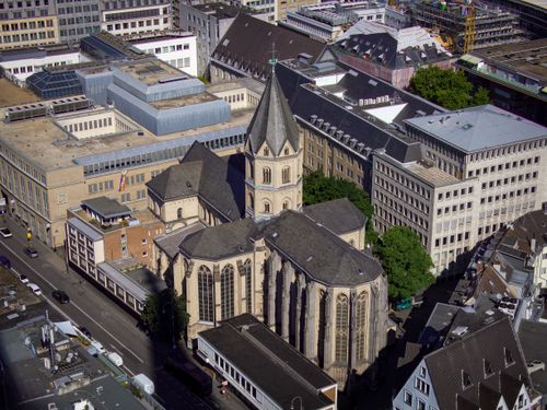 Free Aerial shot of a historic church surrounded by modern urban buildings. Stock Photo