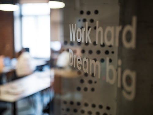 Selective Focus Photography of Work Hard Dream Big Texts on Clear Glass Wall