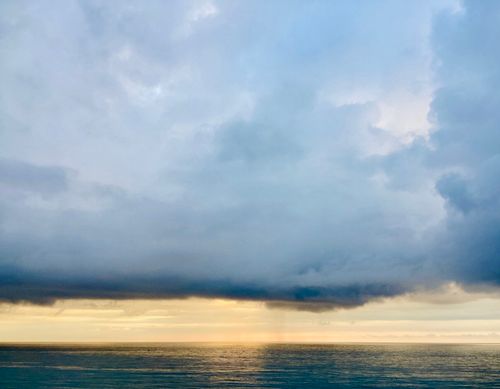 Free A stunning view of a stormy seascape during sunset with dramatic clouds and serene waters. Stock Photo