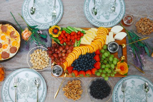 Exquisite arrangement of fruits, cheese, and eggs on a brunch table setting.