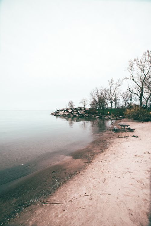 Free Tranquil sandy beach with calm waters at Lake Ontario, Toronto. Perfect for peaceful outdoor retreats. Stock Photo