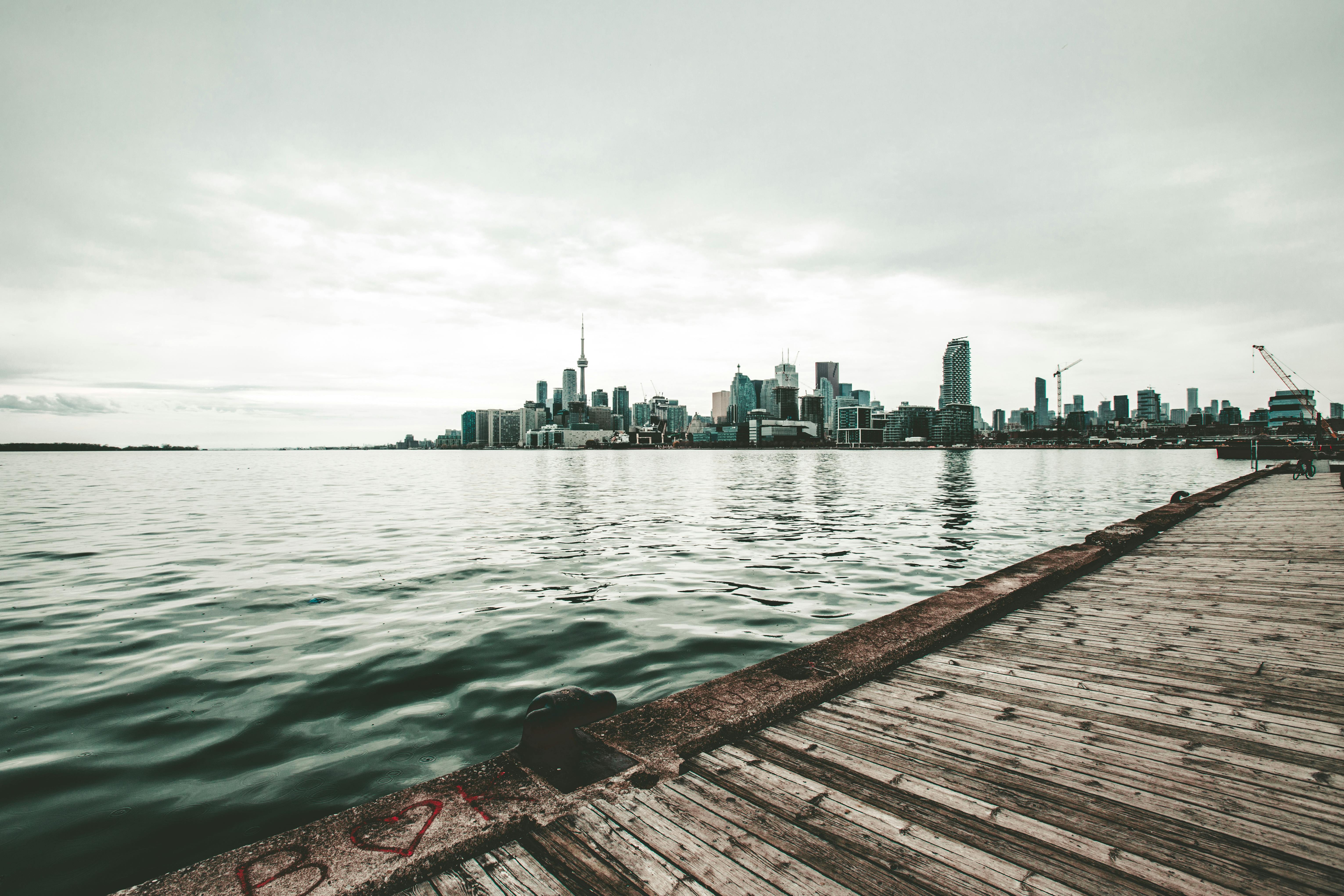 photo of pier against city buildings