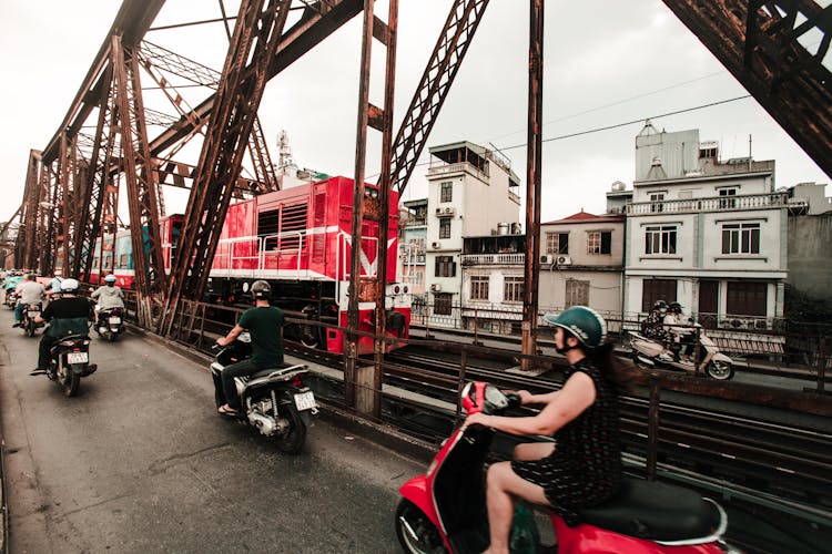 People Riding Motorcycles Near Train