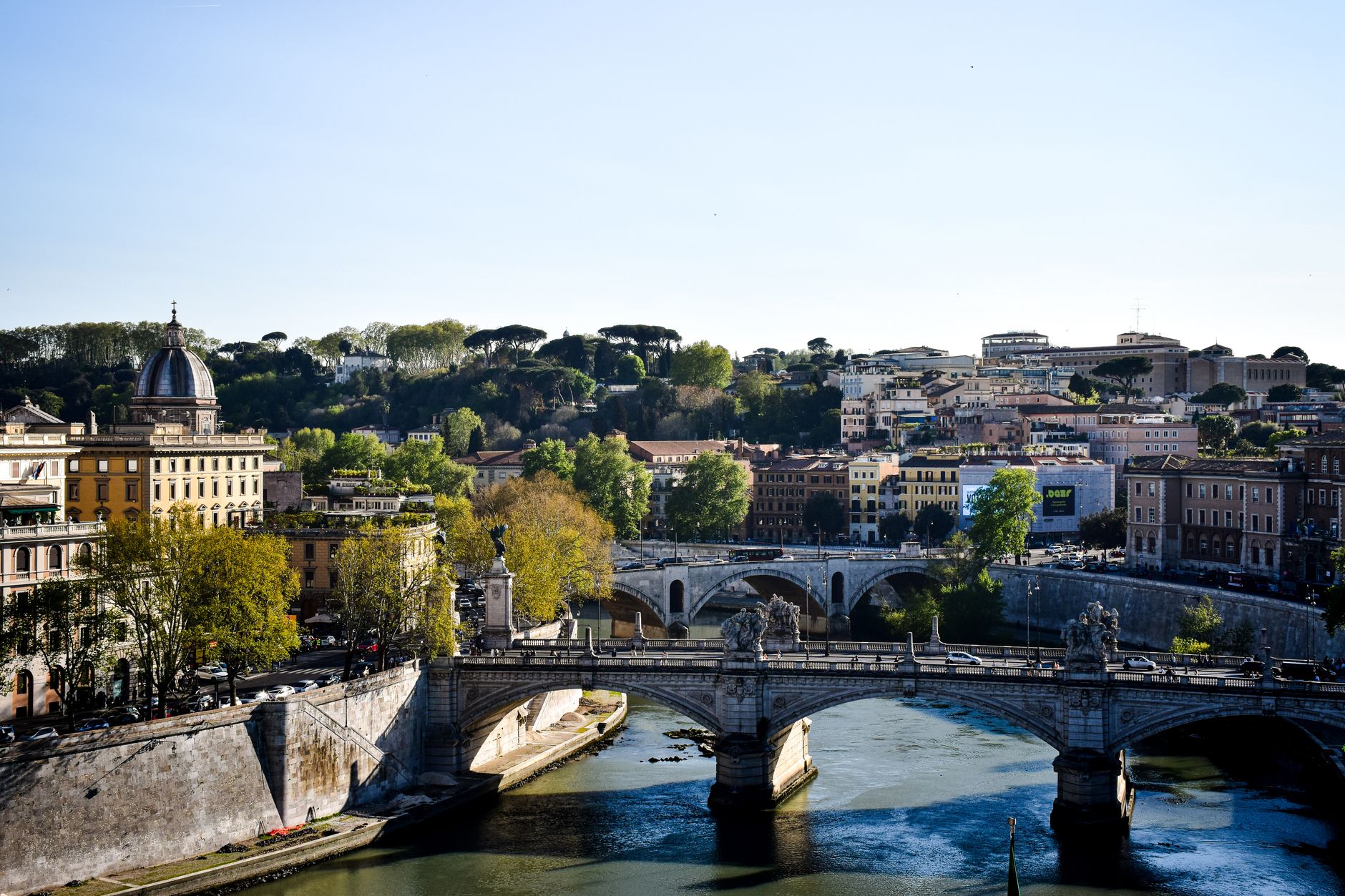 Beautiful view of Ponte Sant'Angelo spanning the Tiber River in Rome, Italy under a clear sky.