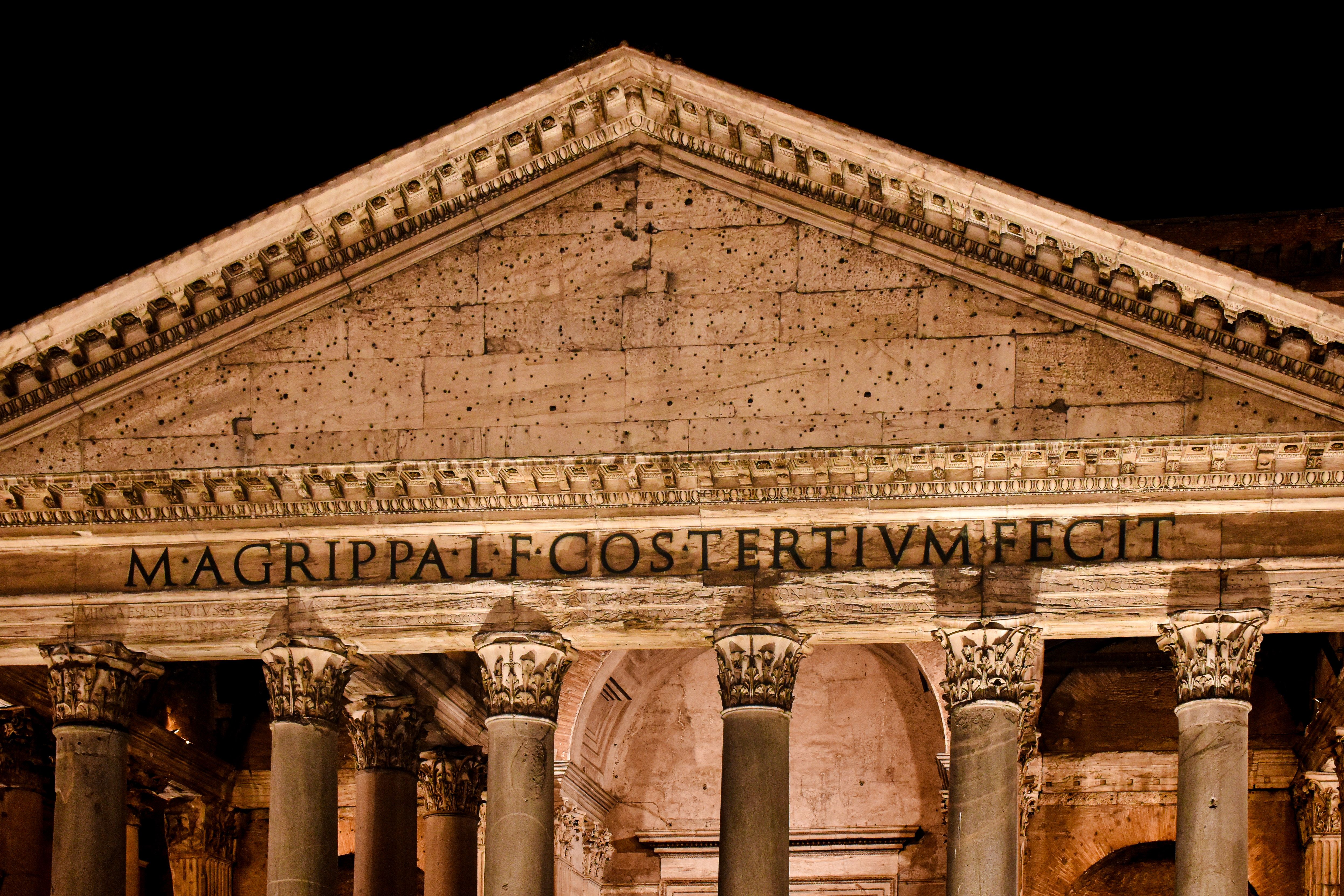 Night tour group viewing illuminated ancient Roman monuments